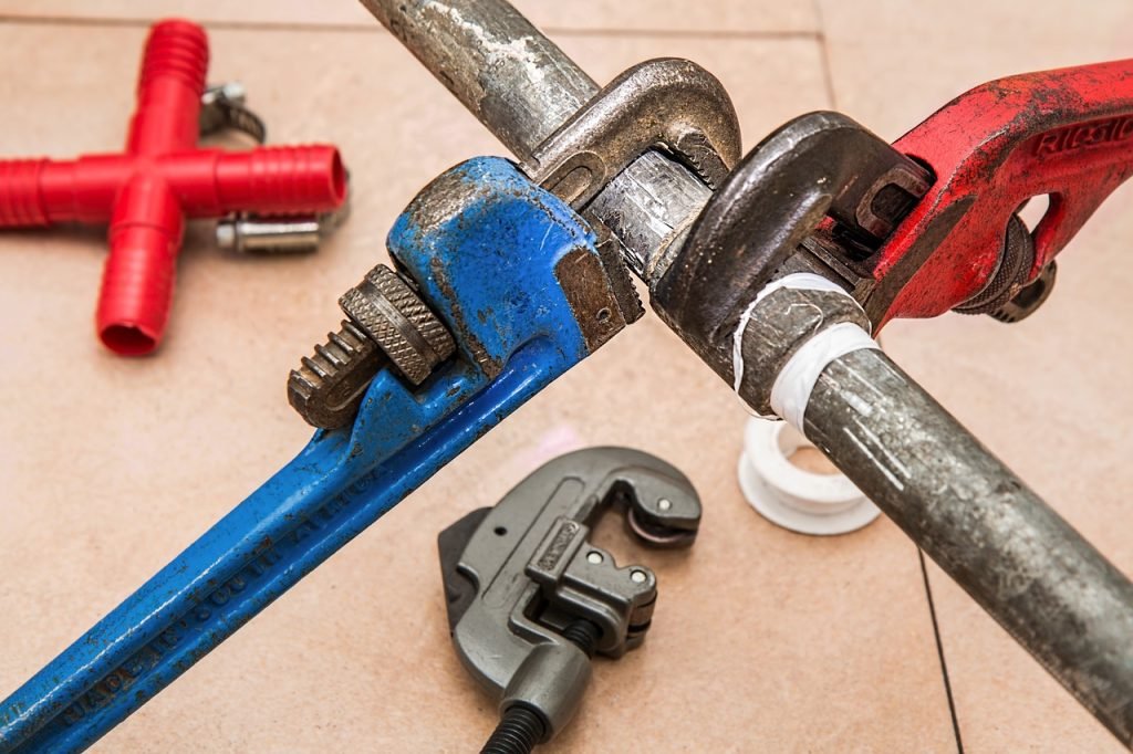 plumber working with pipe wrench